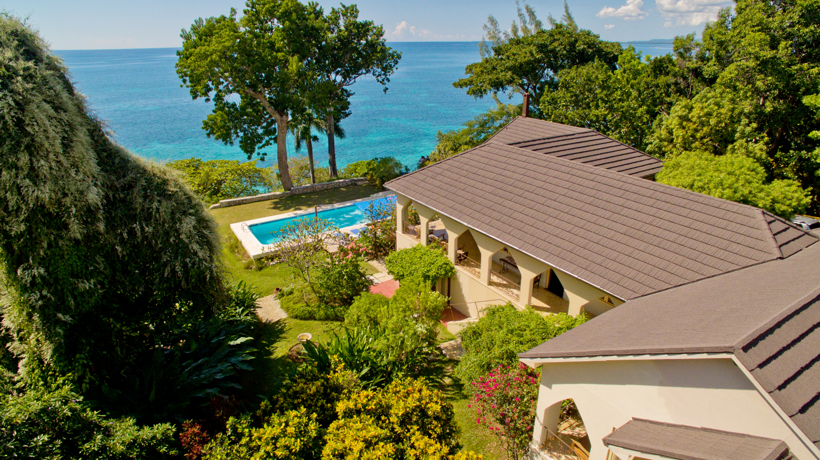 Aerial view of Bluefields Bay psilocybin retreat Jamaica with pool and sea.