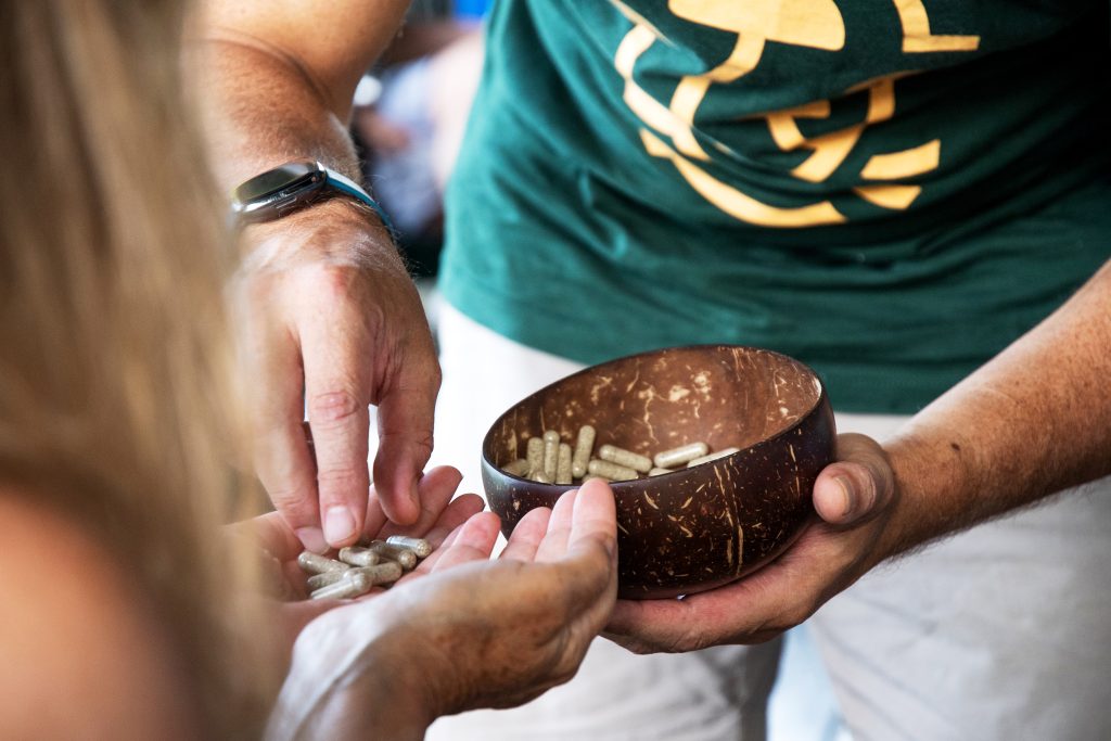 MycoMeditations facilitator administering a psilocybin dose to a guest during a therapeutic session.