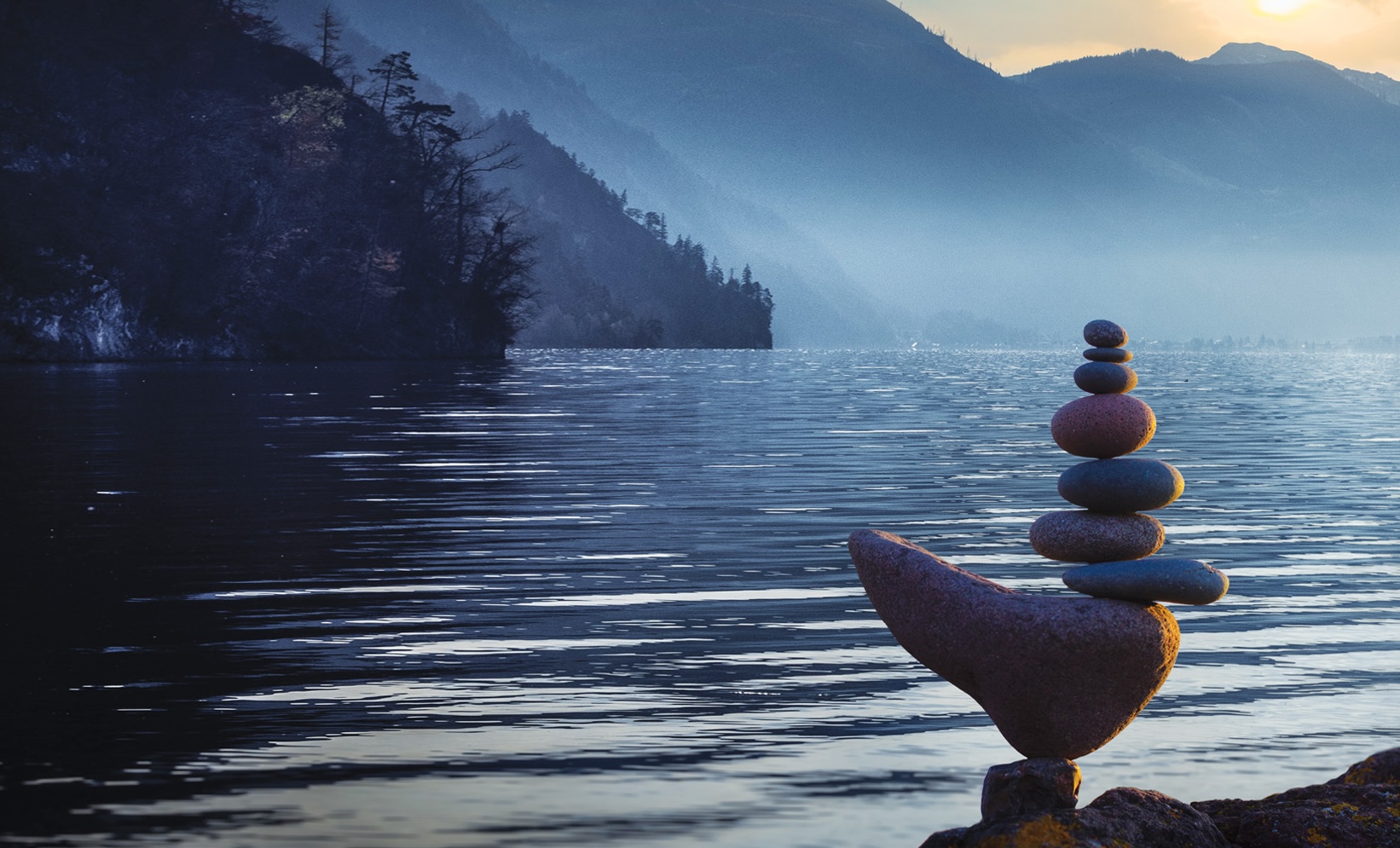 Rocks balancing on the shore of a calm lake