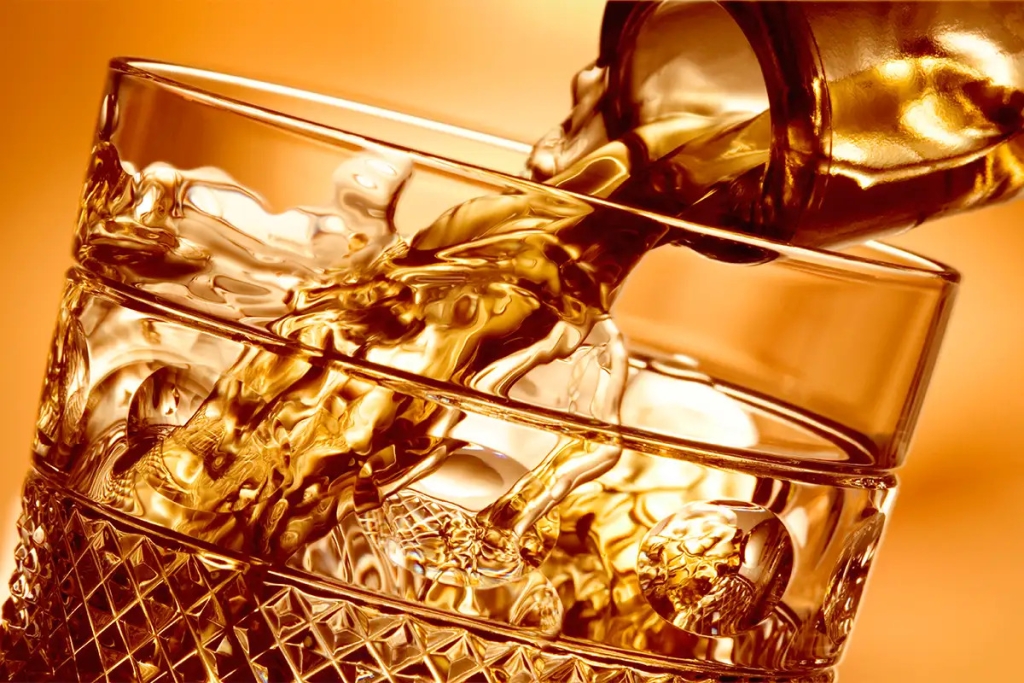 Close up of alcohol being poured into a tumbler glass